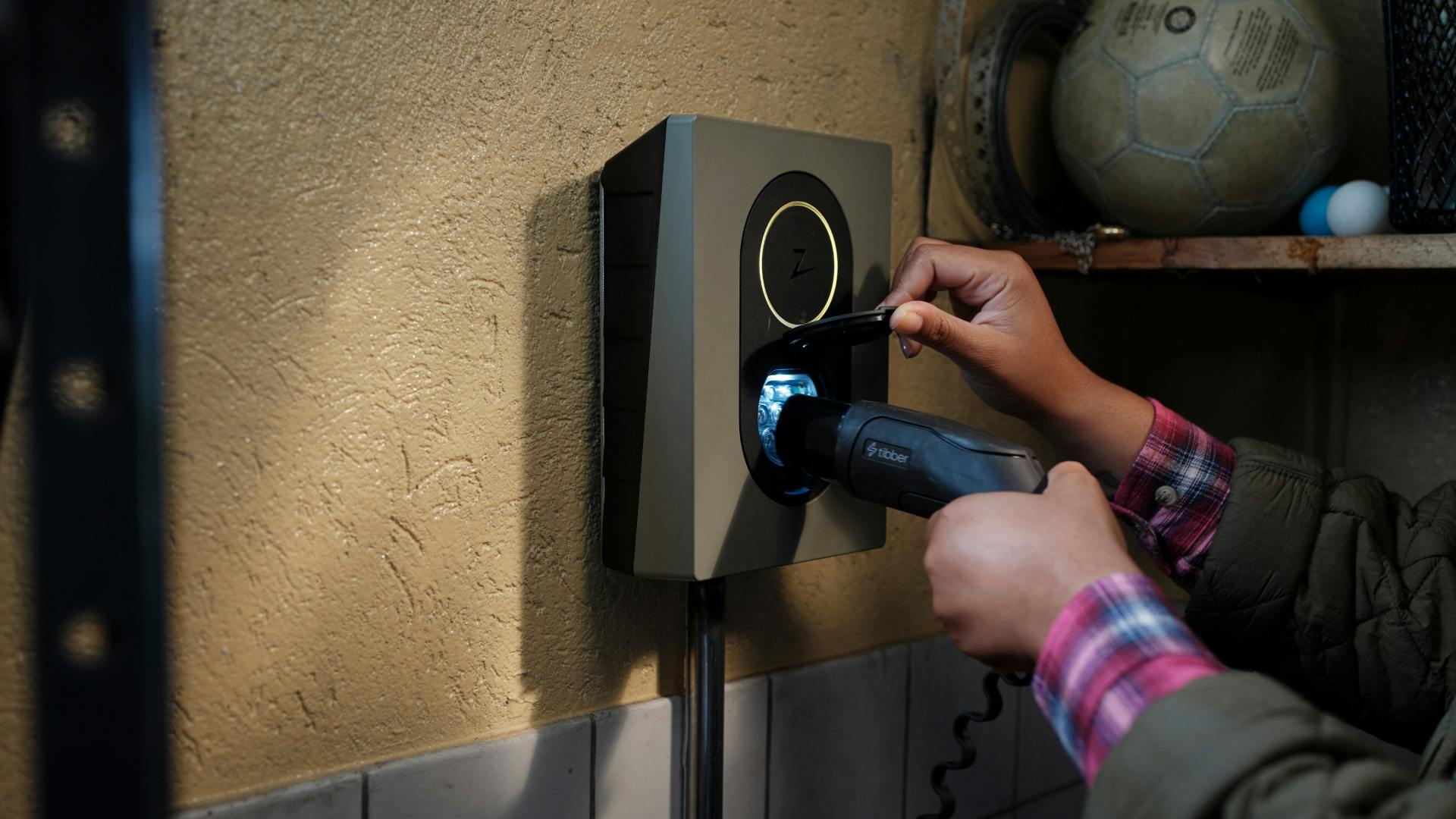 Hand steckt Kabel in Zaptec-Ladebox
