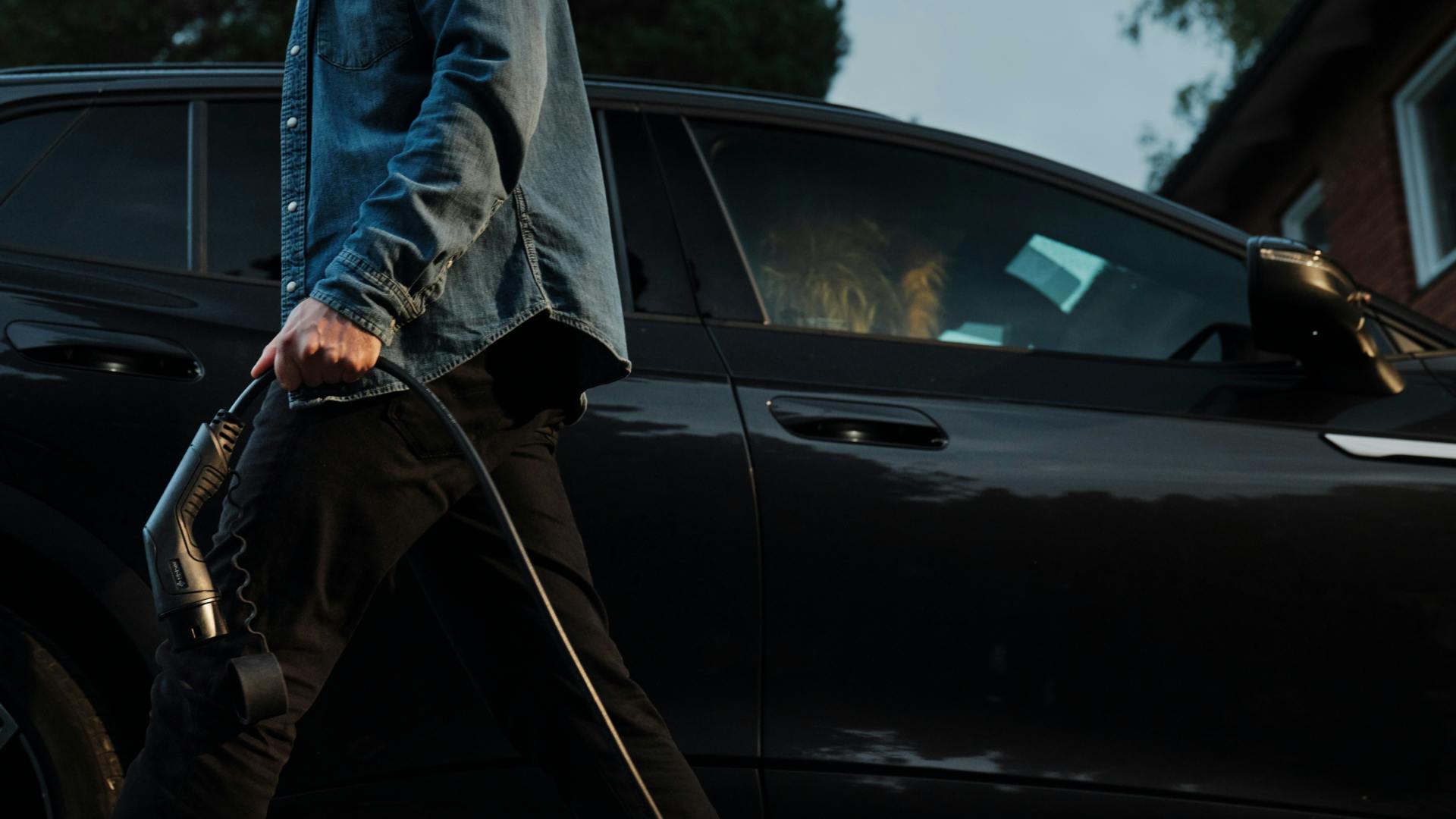 Mann lehnt sich über seinen Tesla