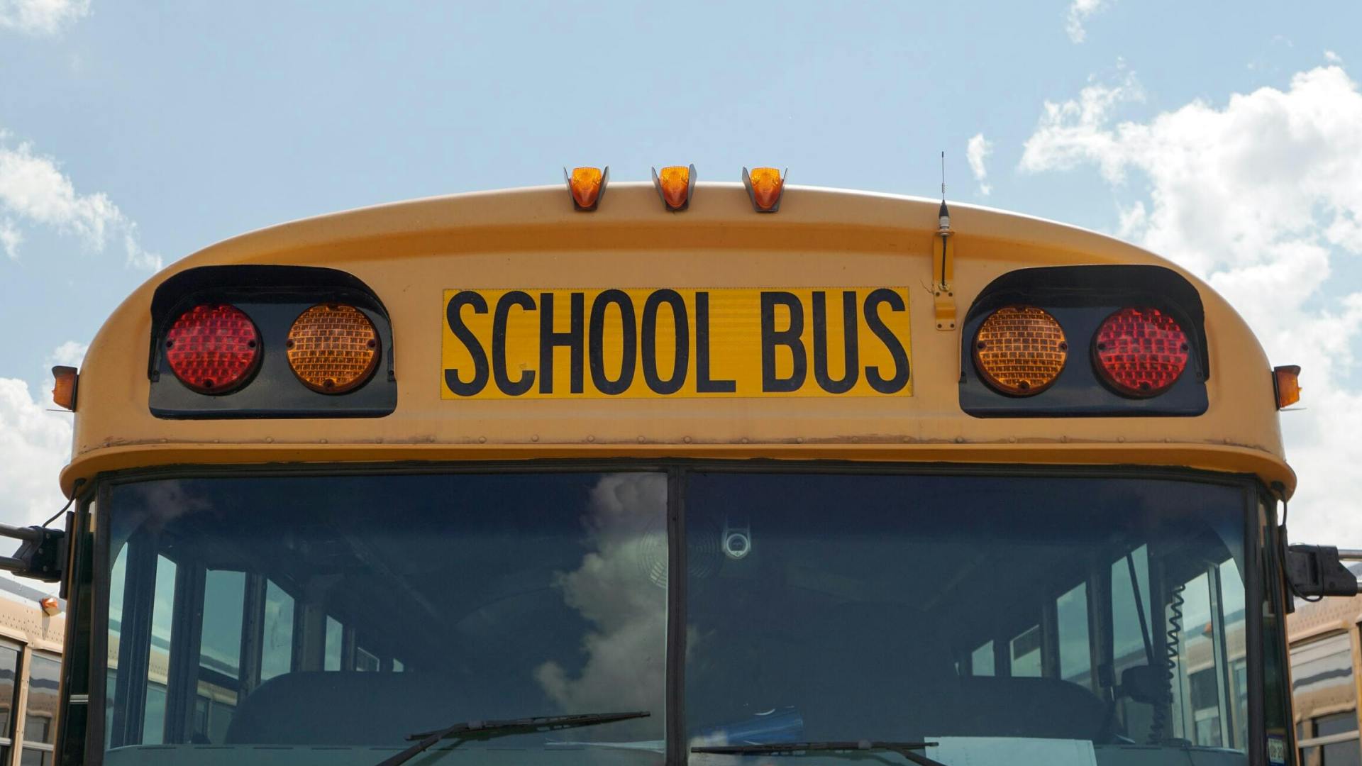 Front side of an American school bus with blue sky in the background